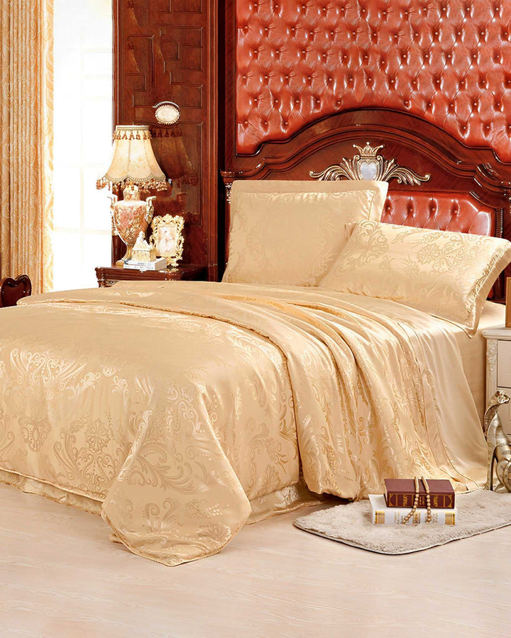A luxurious bedroom features a double bed adorned with the 19 Momme Jacquard Silk Bedding Set (4Pcs) from SusanSilk, an ornate tufted headboard, vintage lamps, and decorative pillows on a cream-colored bedside table.