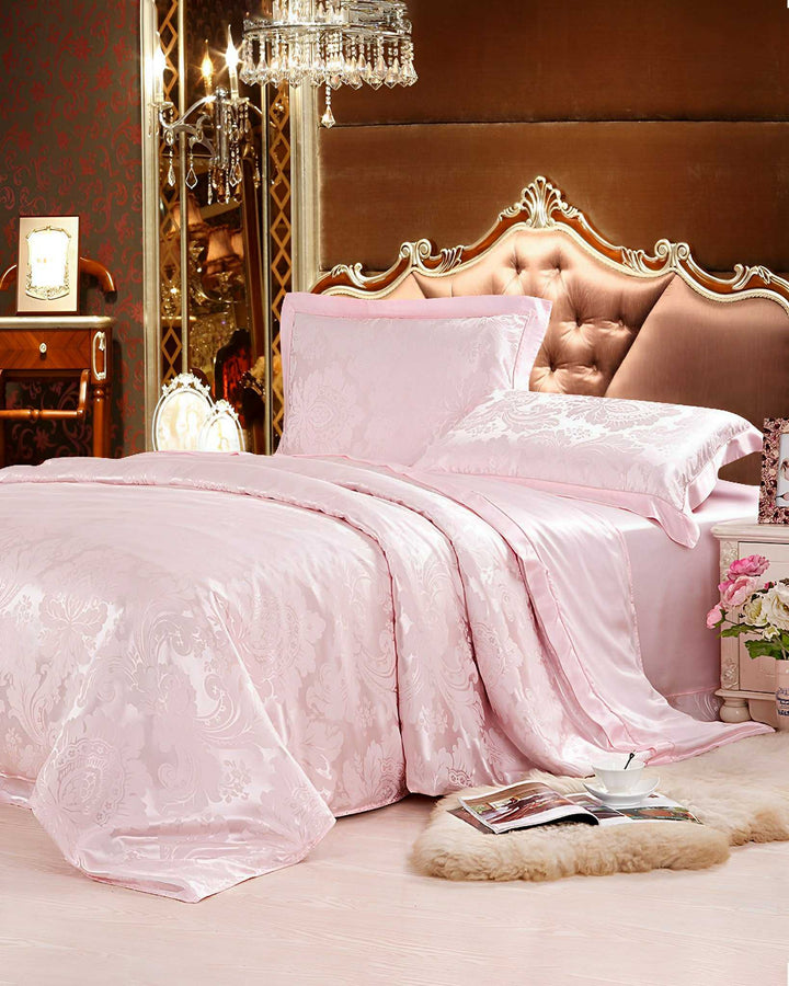 Luxurious bedroom featuring an ornate headboard, a SusanSilk 19 Momme Jacquard Silk Bedding Set - 4Pcs in a pink satin finish, a chandelier, and a plush rug on the floor. The room is adorned with elegant furniture and rich decor.