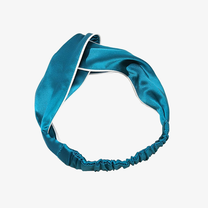 Introducing the SusanSilk Piping Criss Cross Silk Headband, featuring a luxurious teal satin design with white trim and a comfortable elastic section at the back.