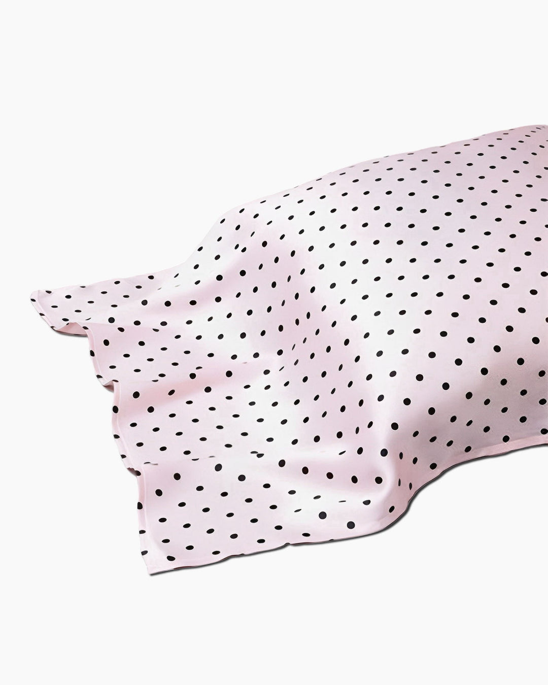 A 19 Momme Printing Silk Pillow Cover in pink, featuring black polka dots and partially laid out with visible wrinkles, evocative of the luxurious textures from SusanSilk.