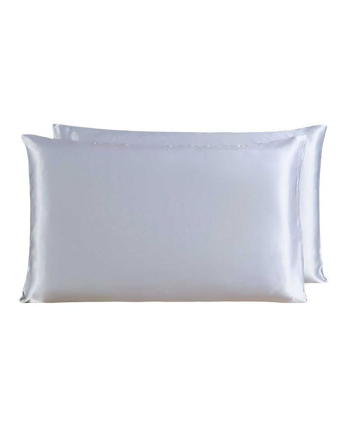 Two SusanSilk 19 Momme Silk Pillowcase Zippers made from luxurious silver silk are stacked together, adding a touch of elegance to any bedroom.