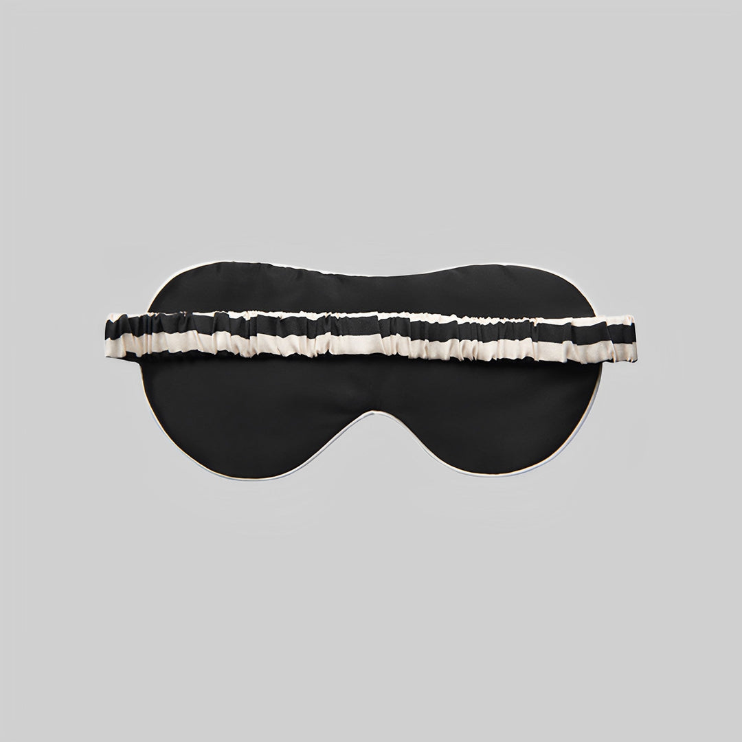 Elegant black 19 Momme Stripe Silk Sleep Eye Mask, featuring a chic white and black striped elastic band, showcased on a plain gray background. A touch of luxury from SusanSilk.