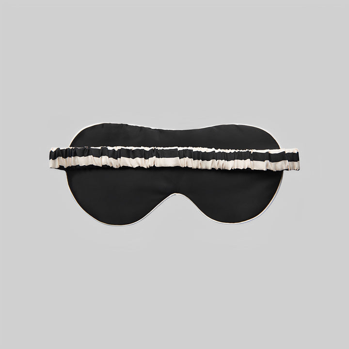 Elegant black 19 Momme Stripe Silk Sleep Eye Mask, featuring a chic white and black striped elastic band, showcased on a plain gray background. A touch of luxury from SusanSilk.
