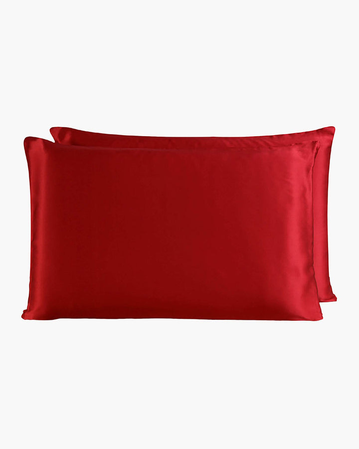 Two luxurious SusanSilk 22 Momme Beauty Silk Pillowcase Zippers in a vibrant red hue, stacked on top of each other against a plain white background.