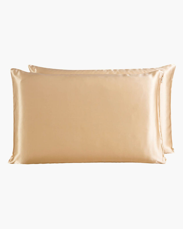 Two luxurious SusanSilk 22 Momme Beauty Silk Pillowcase Zippers, featuring a gold-colored satin finish, stacked elegantly against a white background.
