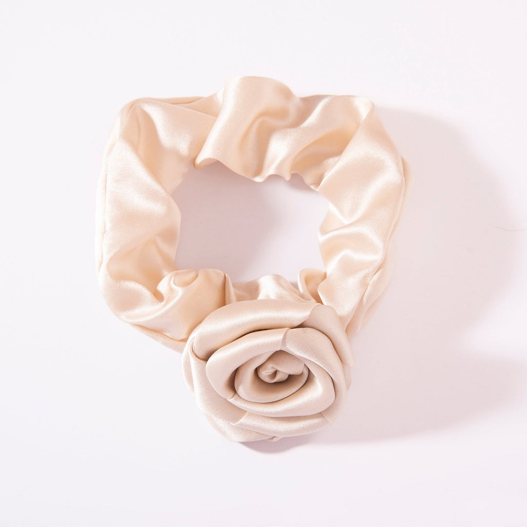 The Elegant Camellia Silk Scrunchie by SusanSilk, featuring a rose-shaped ornament, is displayed against a white background.