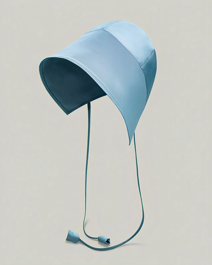 The 22 Momme Silk Sunshade Bonnet Hat by SusanSilk, featuring extended panels and two dangling straps, is showcased in a light blue hue against a neutral background.