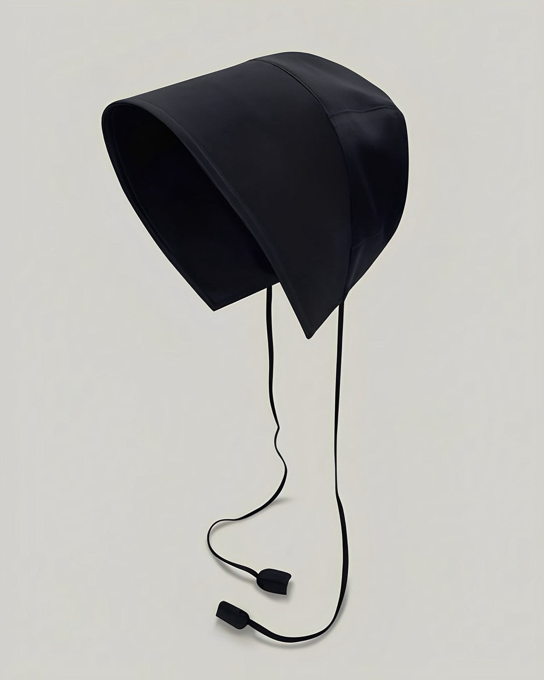 Presenting the 22 Momme Silk Sunshade Bonnet Hat by SusanSilk, a black bonnet-style hat crafted from luxurious silk, featuring an elongated brim and dual string ties with weighted ends, showcased against a plain background.