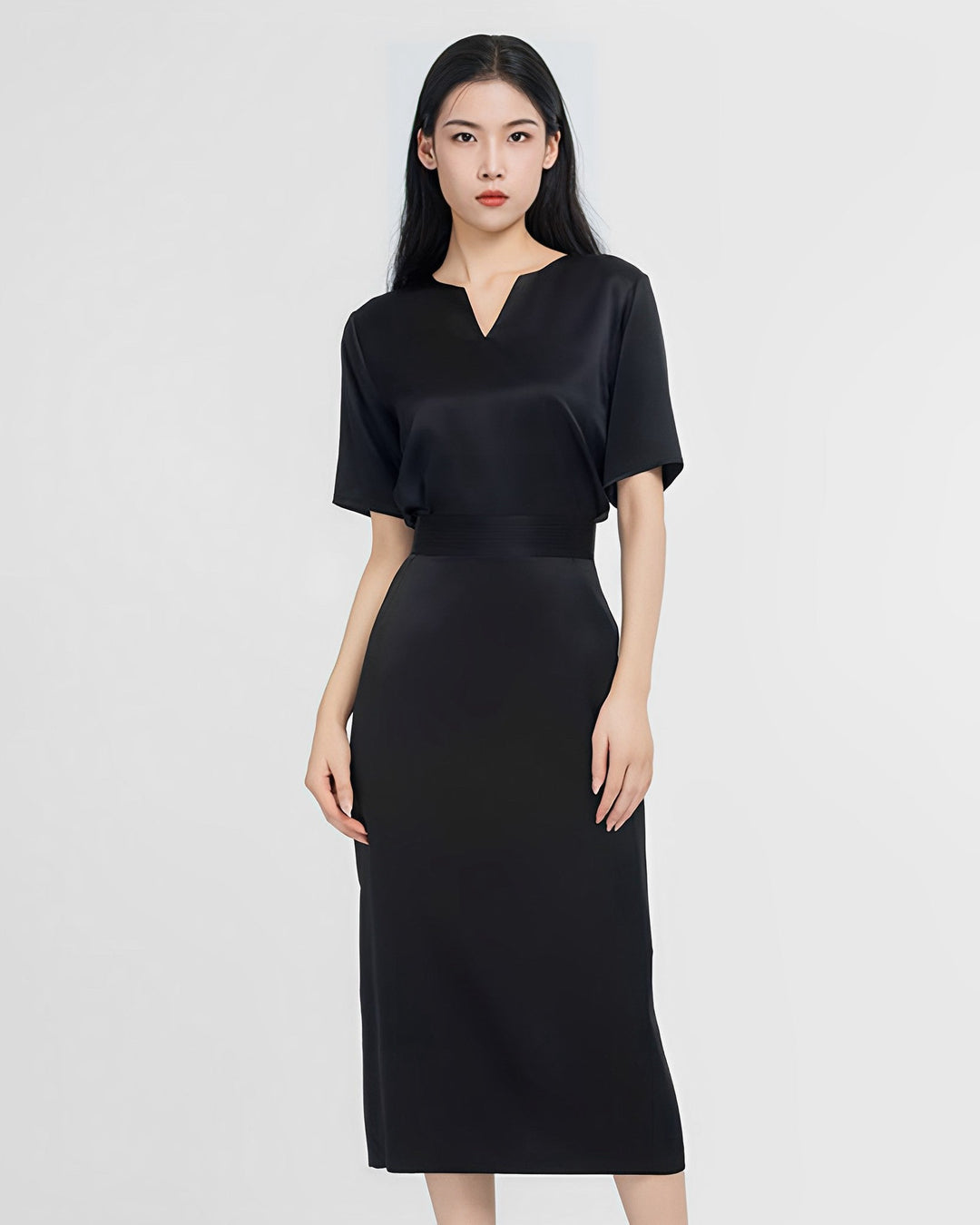 A woman with long black hair is wearing a short-sleeved, knee-length dress from the Elegant Two-Piece Silk Dress Set by SusanSilk. She is standing against a plain, light-colored background.