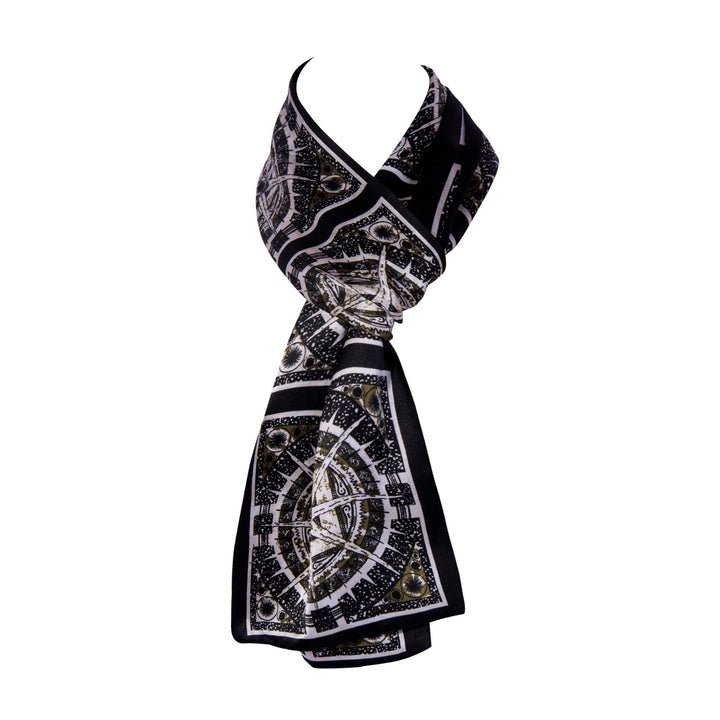 The SusanSilk Black Compass Narrow Long Silk Scarf, featuring an intricate geometric pattern, is elegantly wrapped and draped, displayed on a plain white background.