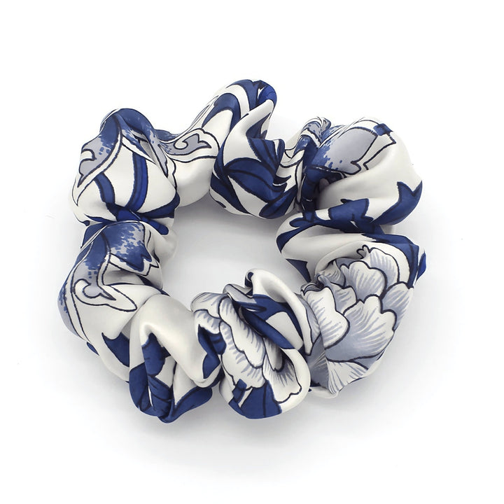 Introducing the Celadon Print Silk Scrunchies Set 3-Pack by SusanSilk, featuring a luxurious white and navy blue scrunchie adorned with a delicate floral pattern on a white background.