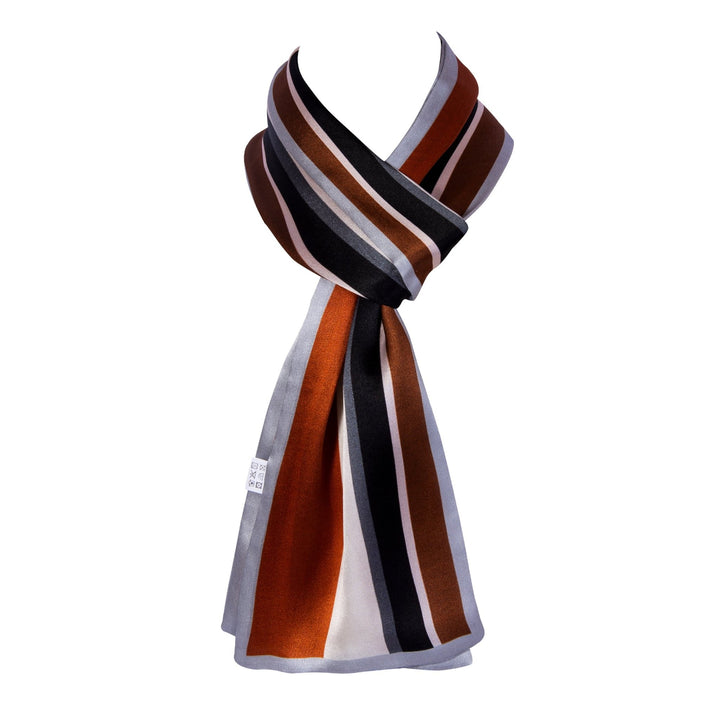 SusanSilk's Color Strips Narrow Long Silk Scarf, featuring a multicolored design with striped patterns in black, brown, orange, and white, is neatly tied in a loop knot.