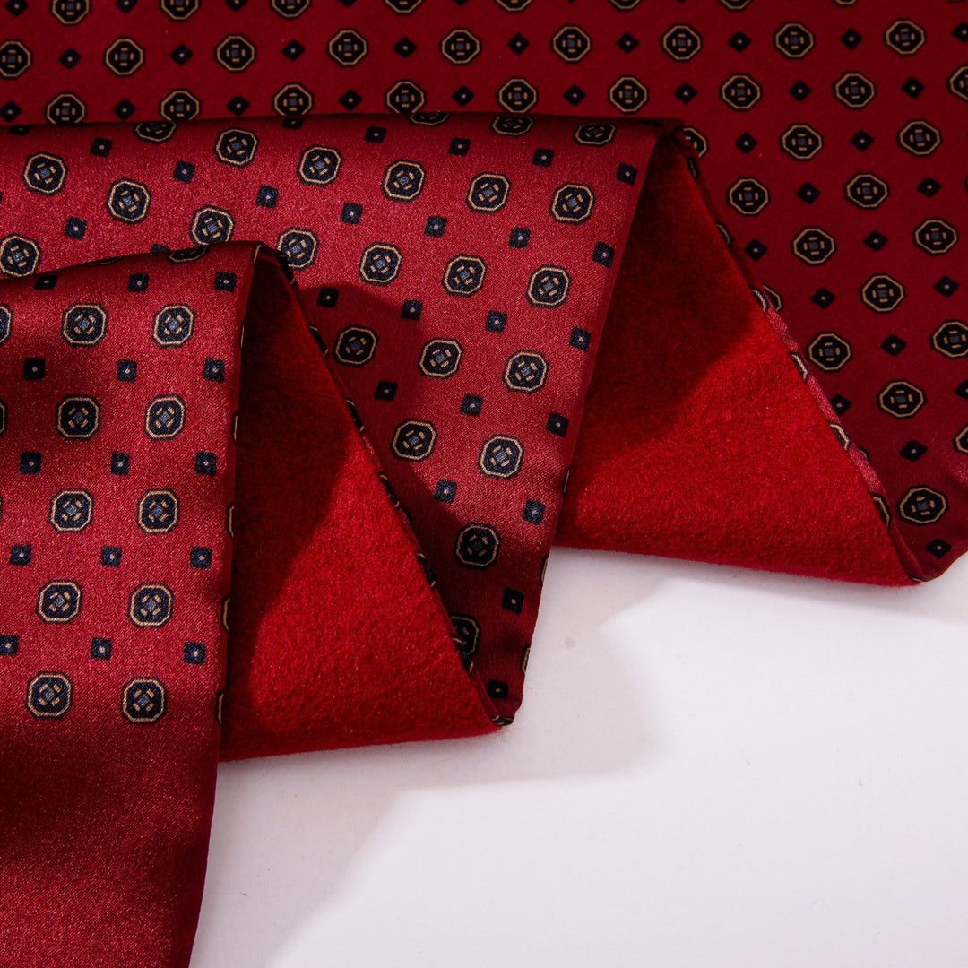 Close-up of a folded Geometric Pattern Long Silk Brushed Scarf - Garnet by SusanSilk, showcasing a black and white geometric pattern. The scarf features small hexagonal shapes and is partially unfolded on a white surface.