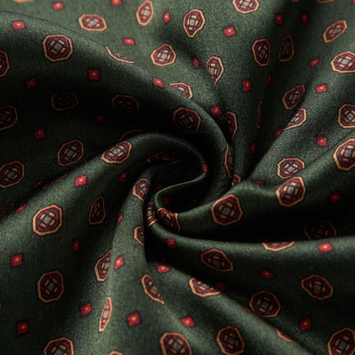 Close-up of the SusanSilk Geometric Pattern Long Silk Brushed Scarf in green, showcasing intricate swirling patterns with small red and gold geometric designs.