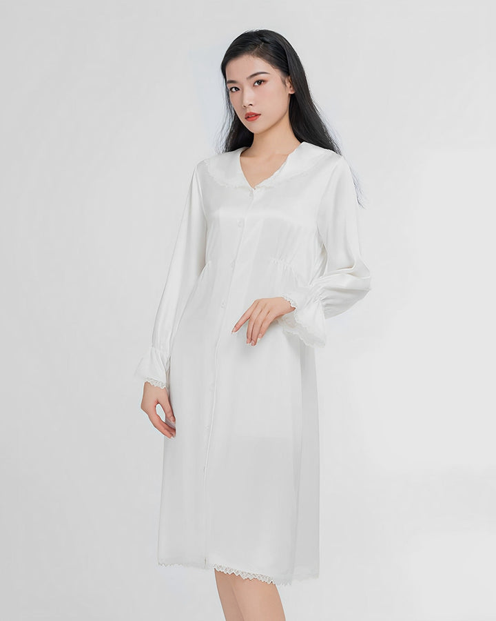 A woman in a white, long-sleeved Premium Lace Silk Nightdress from SusanSilk stands against a plain background, looking forward.