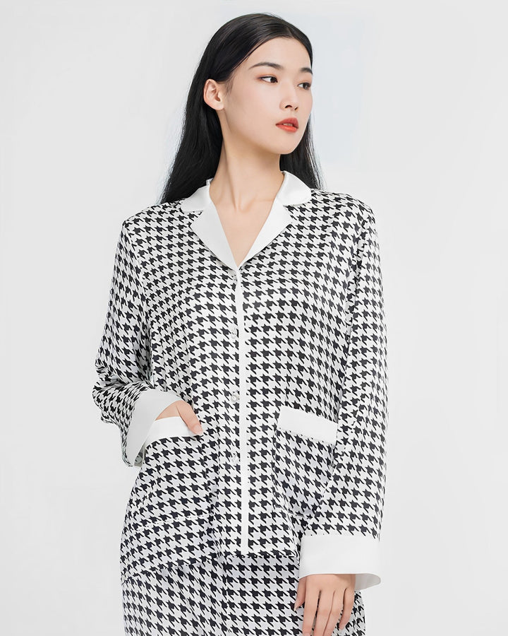 A woman with long black hair wears the SusanSilk Houndstooth Silk Pajamas Set, looking to her left with her right hand in her pocket.