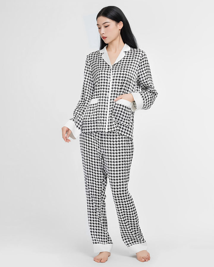 A person stands barefoot wearing the Houndstooth Silk Pajamas Set from SusanSilk against a plain white background.