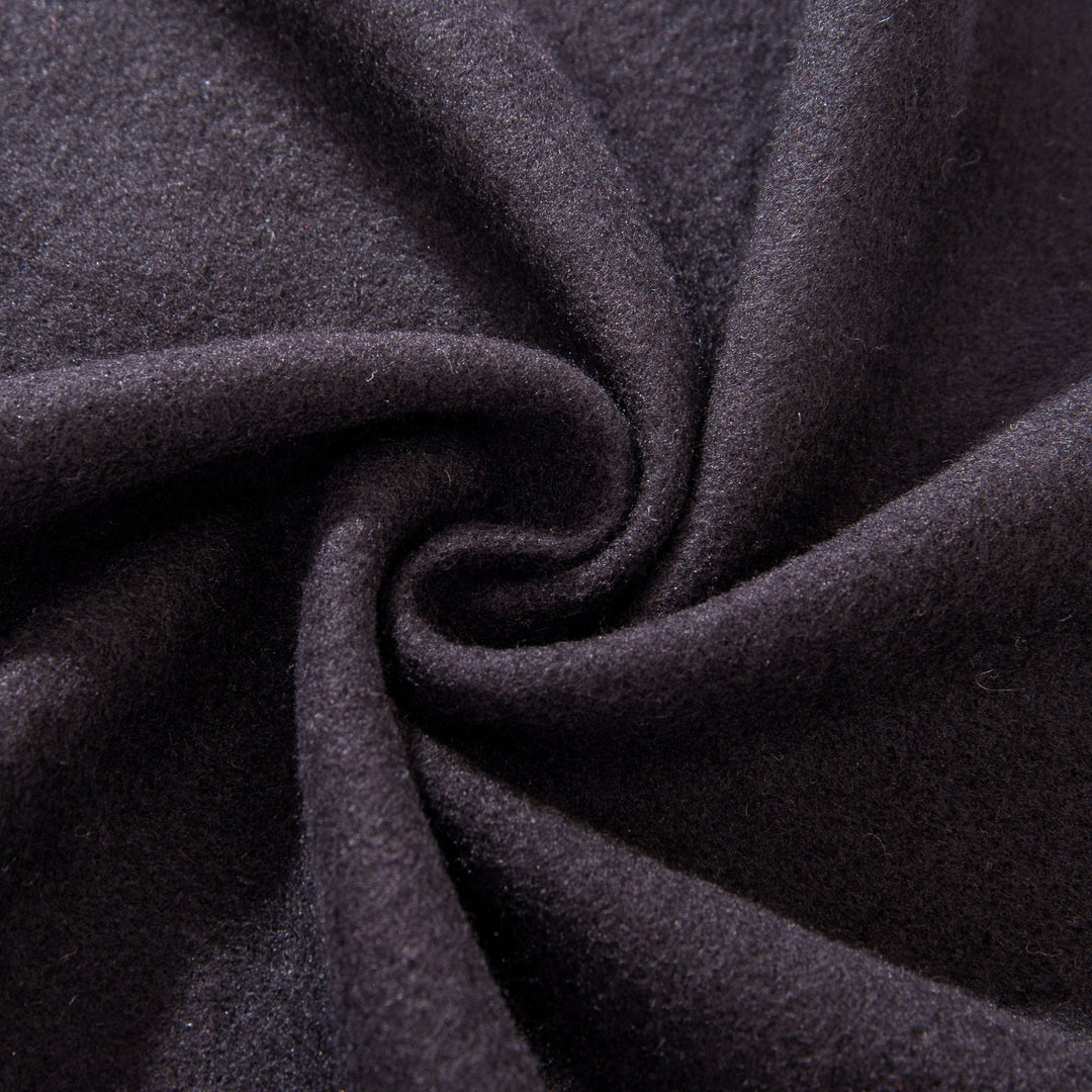Close-up of the Mix Pattern Long Silk Brushed Scarf by SusanSilk, showcasing its black silk fabric with a central swirl pattern. The texture appears soft and smooth.
