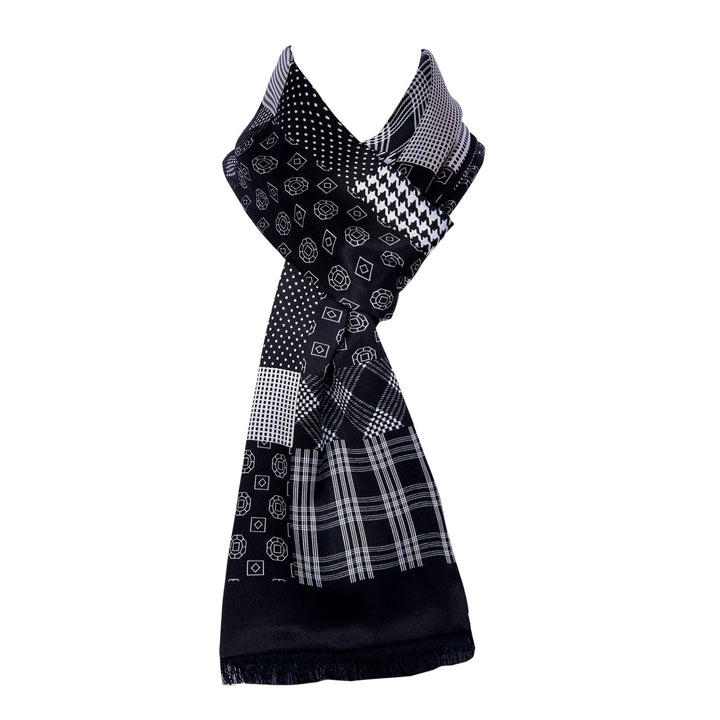 The Mix Pattern Long Silk Brushed Scarf by SusanSilk, featuring an array of geometric patterns such as checks, dots, and cubes in black and white, is elegantly displayed upright against a plain white background.