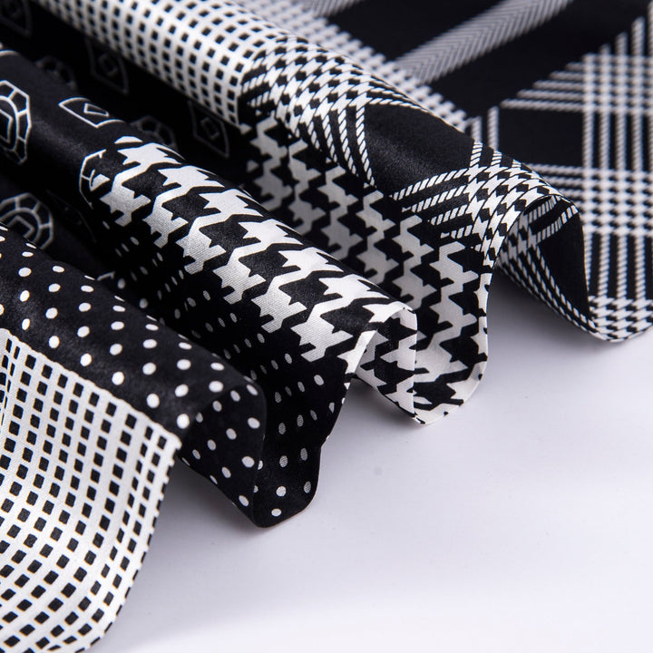 Close-up of various black and white fabric swatches, including polka dots, houndstooth, geometric shapes, and plaid. Some of the swatches feature luxurious SusanSilk's Mix Pattern Long Silk Scarf for an elegant touch.