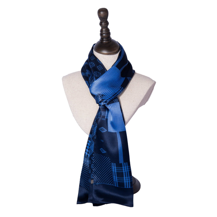 A display mannequin draped with the SusanSilk Mix Pattern Long Silk Scarf on a black stand against a white background.