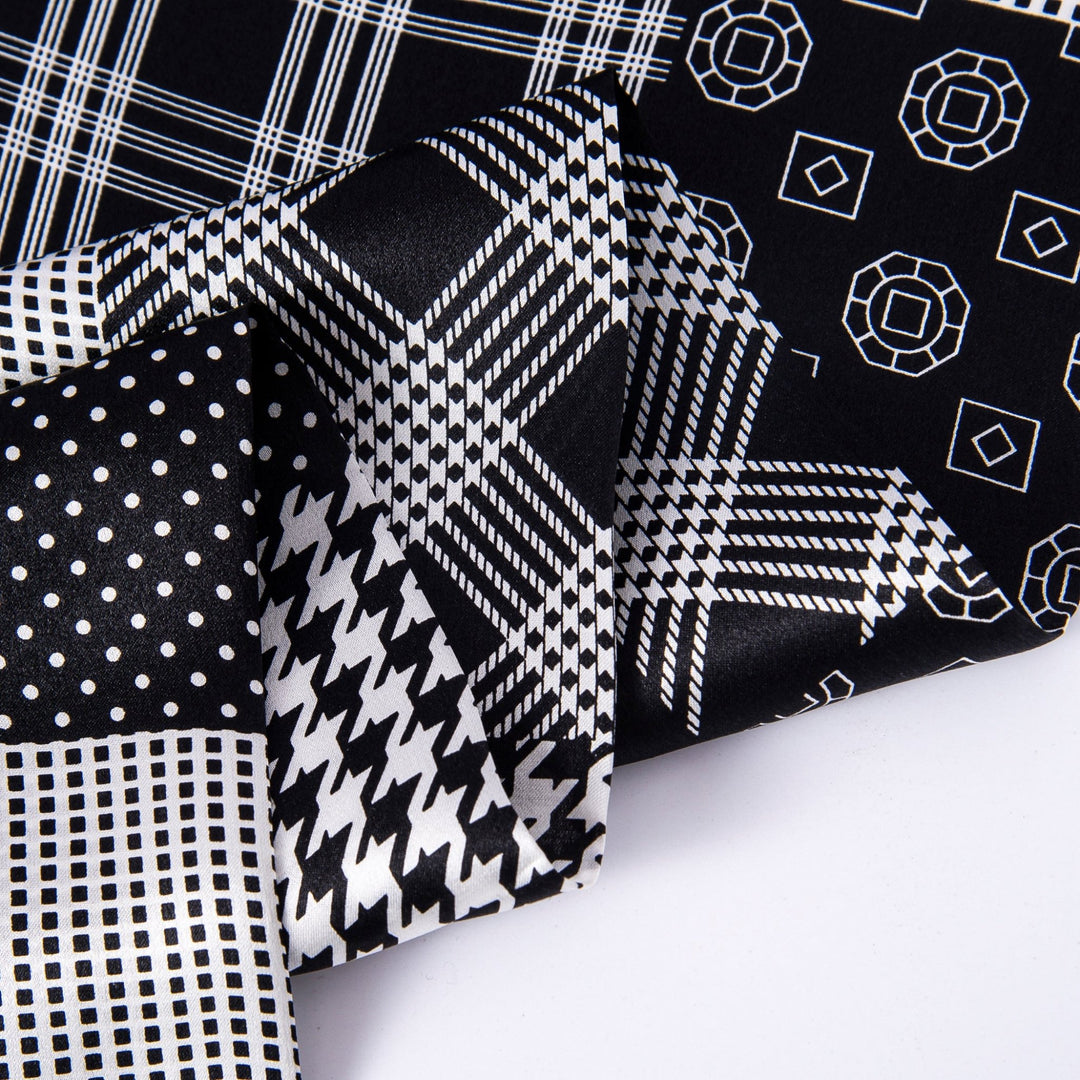 Close-up of various black and white patterned textiles overlapping each other, featuring polka dots, houndstooth, grid lines, and geometric shapes. Among them, a luxurious piece of the Mix Pattern Long Silk Scarf by SusanSilk stands out with its sleek texture.