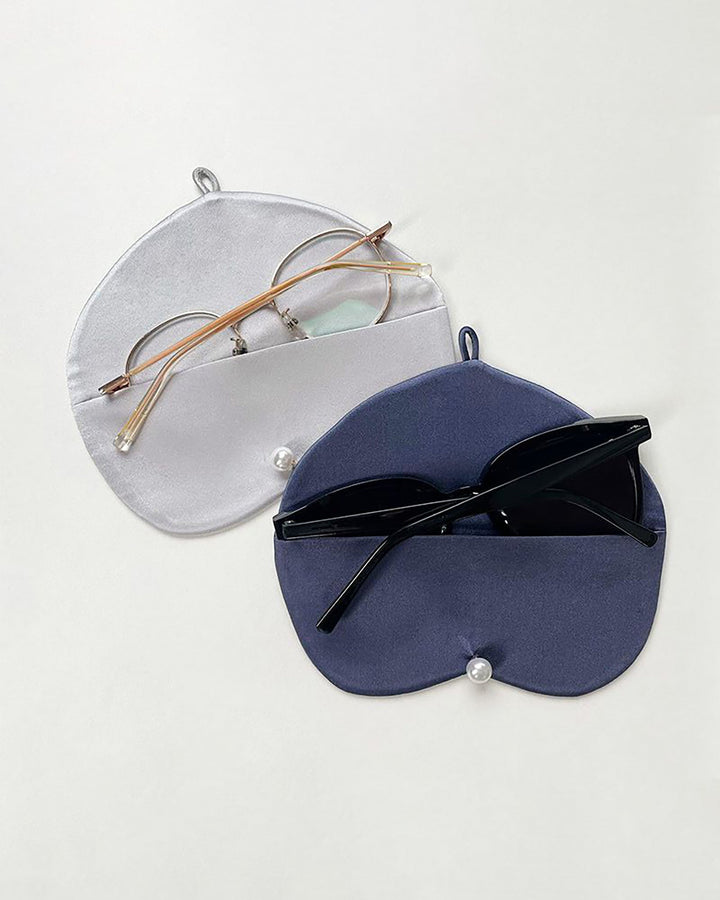 Two **SusanSilk Stylish Silk Glasses Pouches** with snap buttons: one grey holding a pair of round eyeglasses, and one blue holding a pair of black sunglasses, both resting on a light background.