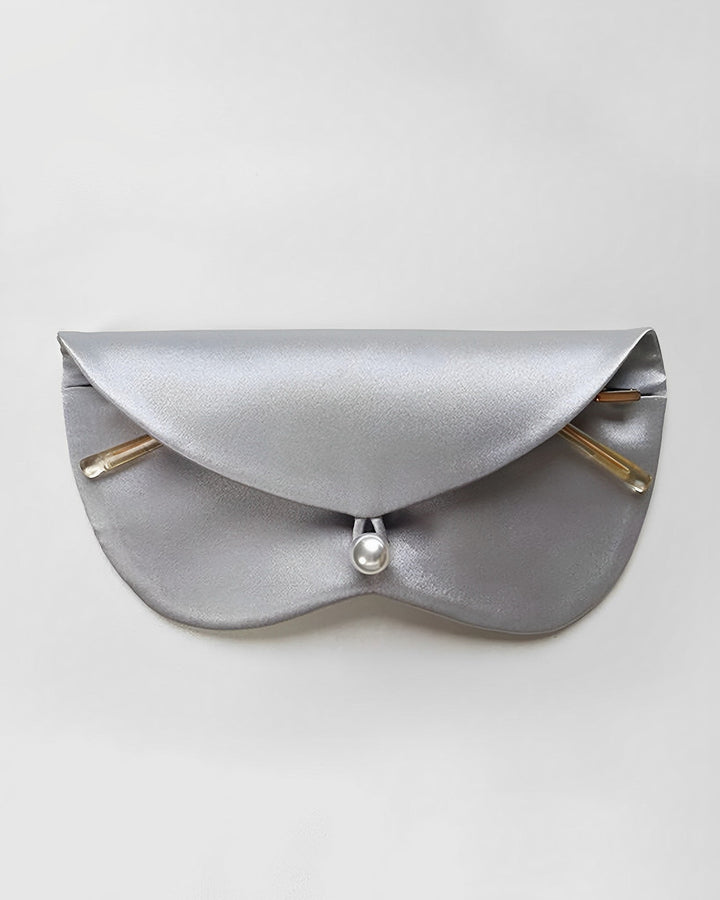 A grey, semi-circular Stylish Silk Glasses Pouch by SusanSilk, featuring a button closure and two gold-toned rods on either side of the flap, crafted from luxurious SusanSilk material, against a plain background.