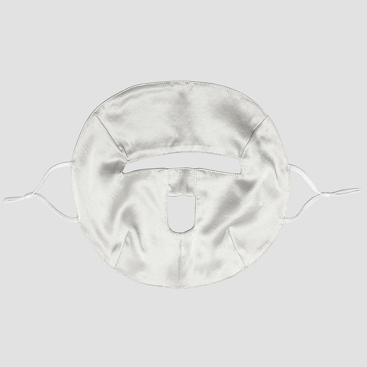 Introducing the Beauty Silk Face Mask by SusanSilk, a white silk fabric mask featuring cutouts for the eyes, nose, and mouth. It comes with ties on both sides to ensure a secure fit.