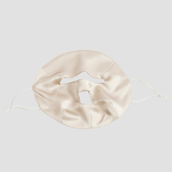 A beige Beauty Silk Face Mask by SusanSilk featuring ear loops and a central vertical slit.