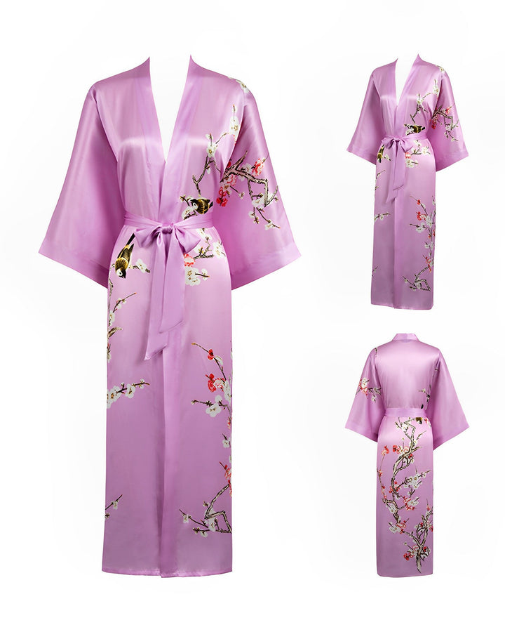 The Plum Blossom Long Silk Kimono by SusanSilk is a luxurious purple silk robe adorned with intricate floral embroidery, featuring wide sleeves and a tie belt. The garment is displayed from the front, side, and back views.