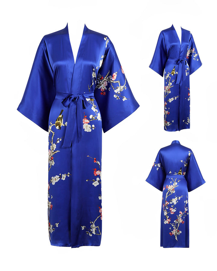 Introducing the Plum Blossom Long Silk Kimono by SusanSilk: a blue, silk kimono-style robe adorned with exquisite floral and bird designs. This luxurious garment features wide sleeves and a sash belt. The image displays front, back, and side views of this stunning piece.
